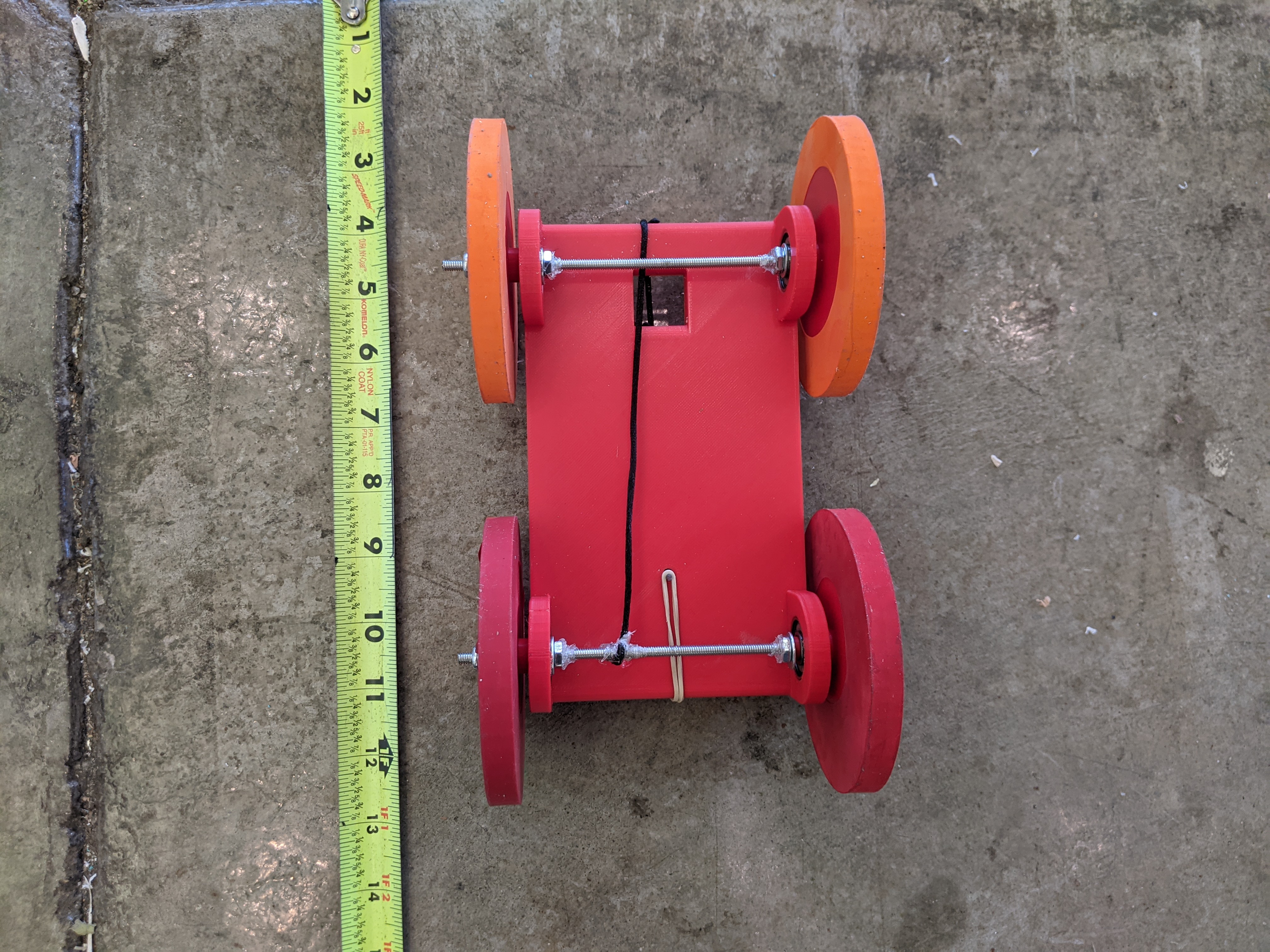 A 3D printed car with a metal axis rotated by a rubber band and a string